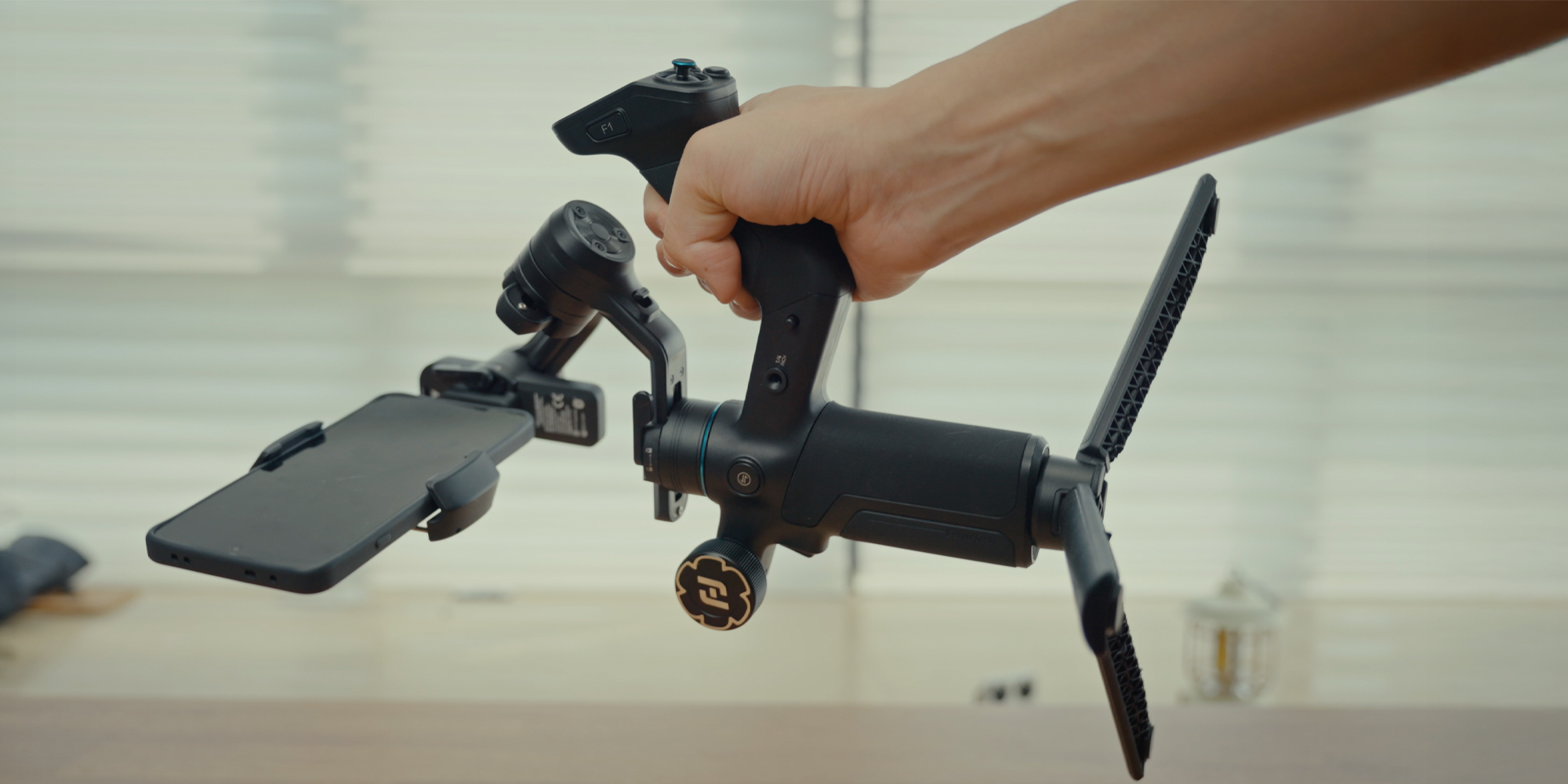 Gimbal ręczny FeiyuTech Scorp mini 3 Pro trzymany za uchwyt boczny z zainstalowanym smartfonem